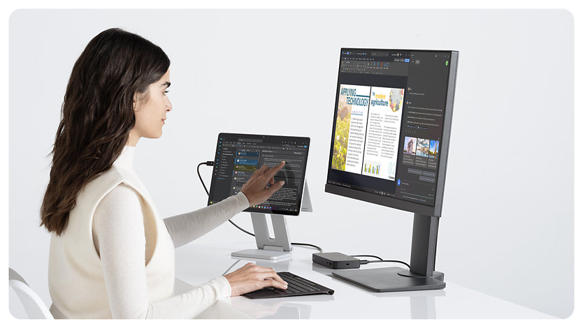 A person uses their hand to scroll on the touchscreen of a Surface Pro for Business.