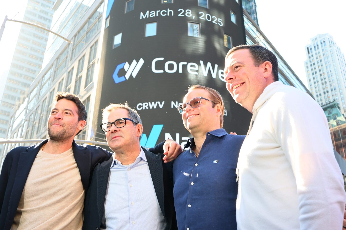 CoreWeave executives pose in front of the Nasdaq building on the day of the company&#039;s IPO.