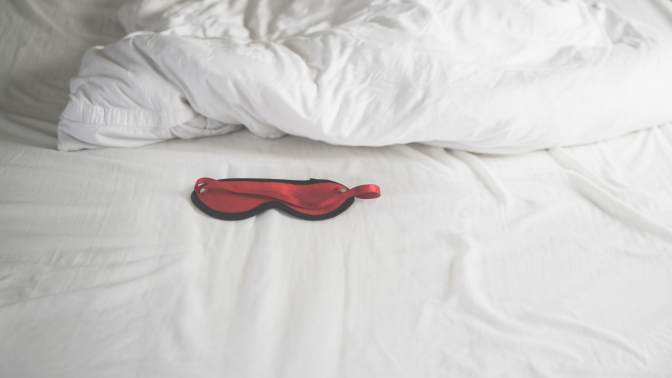 red eye mask on a bed
