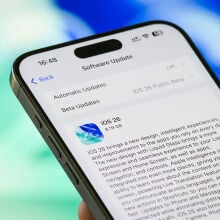 Finger about to press the button to download iOS 26 on an iPhone