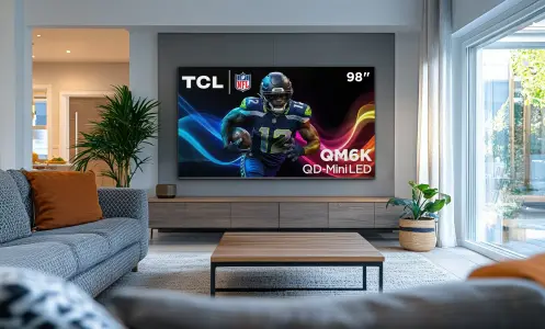 Living room scene featuring TCL TV hanging on wall with football player screensaver