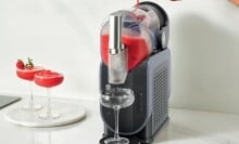 a person pours a bright red liquid into the Ninja slushi machine