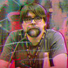 A man sits behind a podium with a microphone in front of him.