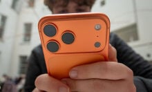 Person holding an orange iPhone 17 Pro
