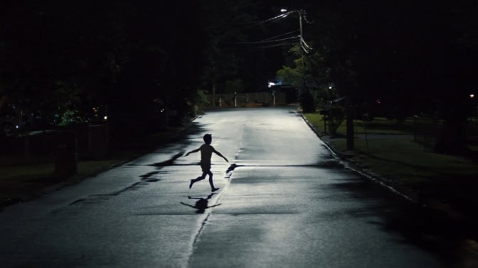 child running in street in still image from "Weapons" movie
