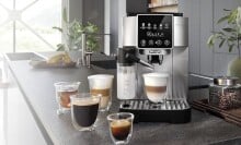 the De'Longhi magnifica start espresso machine on a kitchen counter with several coffee drinks around the machine