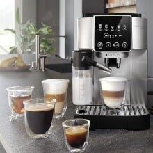 the De'Longhi magnifica start espresso machine on a kitchen counter with several coffee drinks around the machine