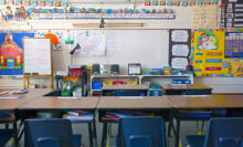 A kindergarten classroom with a whiteboard and decorated walls.