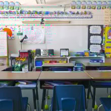 A kindergarten classroom with a whiteboard and decorated walls.