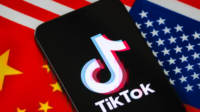 a tiktok logo on a phone with the american and chinese flags behind it