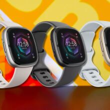 three fitbit sense 2 fitness trackers in a line against a yellow patterned background