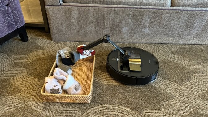 Roborock Z70 robot vacuum picking up sock with robotic arm