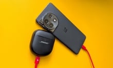A phone and Bose headphones using reverse charging via a USB-C cable, on a yellow background