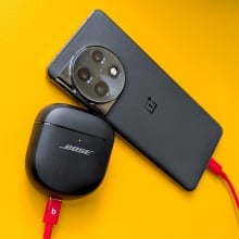 A phone and Bose headphones using reverse charging via a USB-C cable, on a yellow background