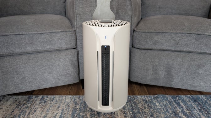 the blueair comfortpure 3-in-1 air purifier in a living room between two chairs