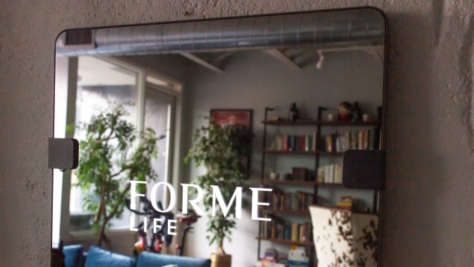 Close-up shot of fitness mirror with a "forme life" decal on it