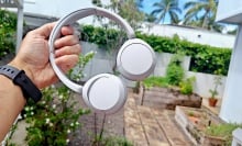 Sony WH-CH520 headphones held in hand outside
