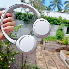 Sony WH-CH520 headphones held in hand outside