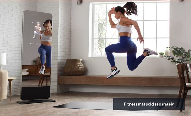 Woman jumping in front of a fitness mirror