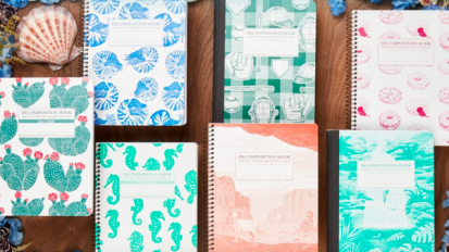 Notebooks with assorted patterns arranged on wood surface