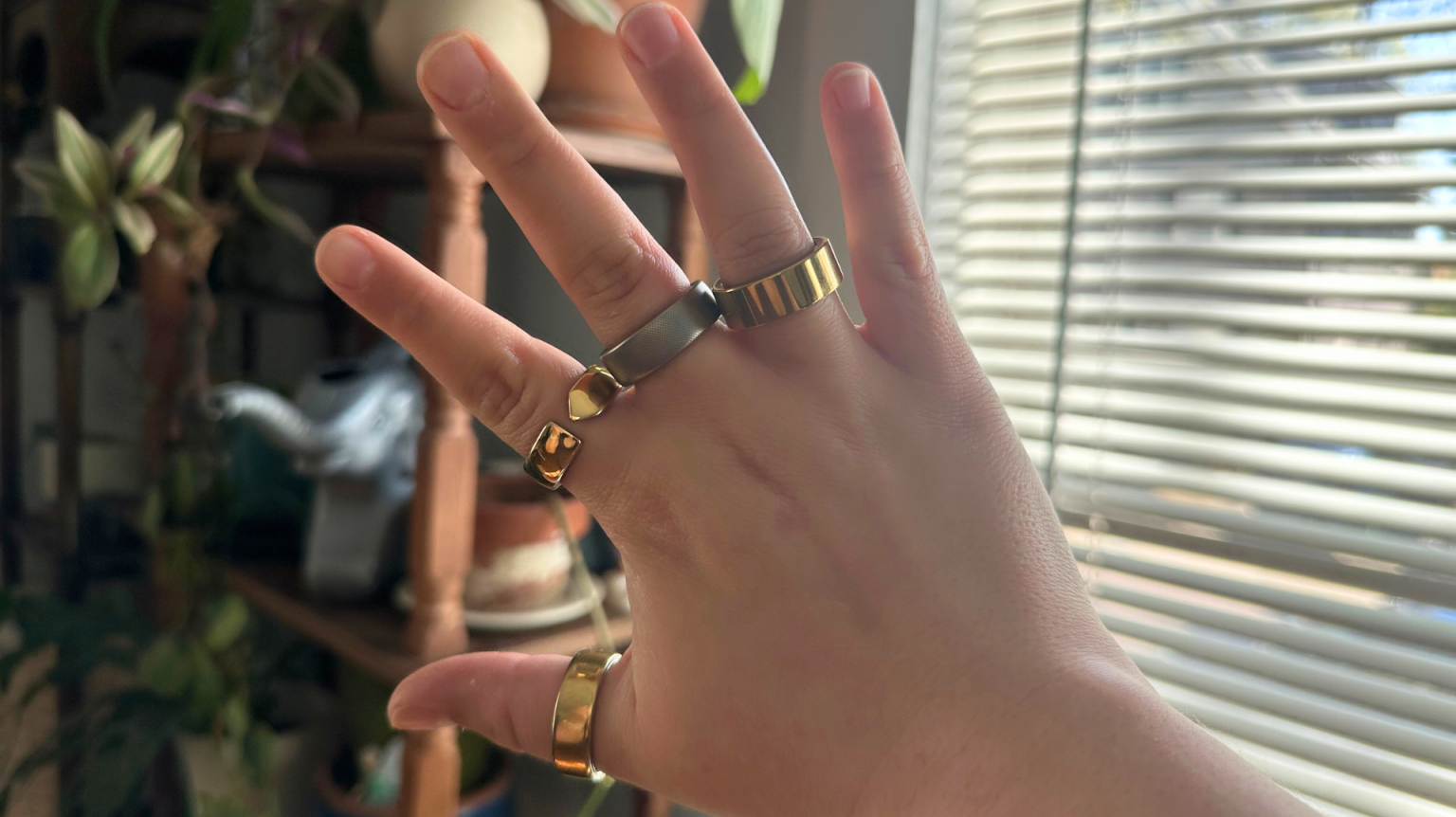 A person wearing four smart rings on one hand.