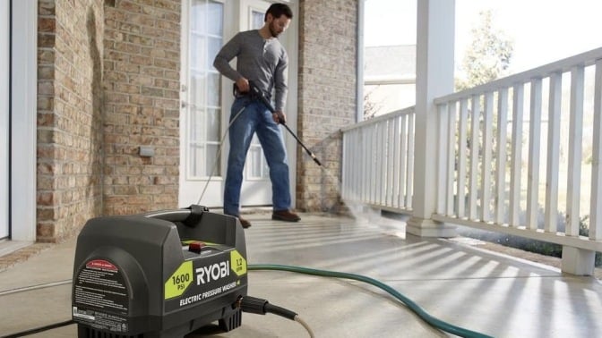 Person using a Ryobi Electric Pressure Washer on a deck.