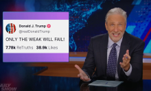 A man sits behind a talk show desk.