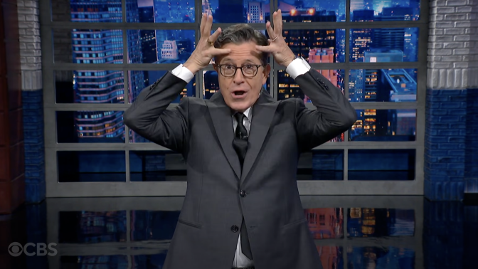 Stephen Colbert holds an imaginary crown over his head presenting "The Late Show."