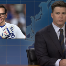 White man in suit and tie at a news desk