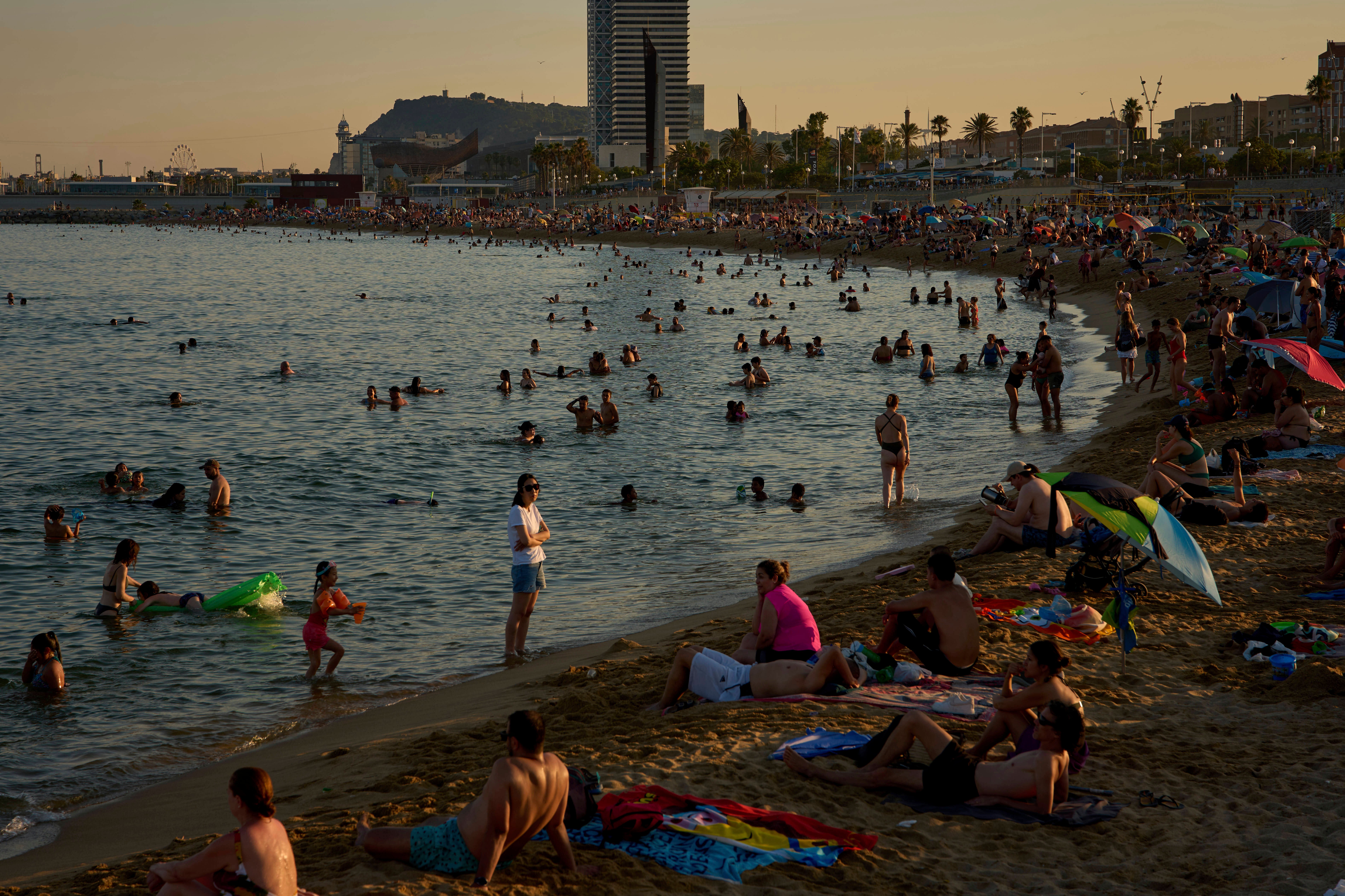 Swimmers cool off in the water at a beach on a hot day in Barcelona, Spain, Sunday, June 29, 2025. (AP Photo/Emilio Morenatti)